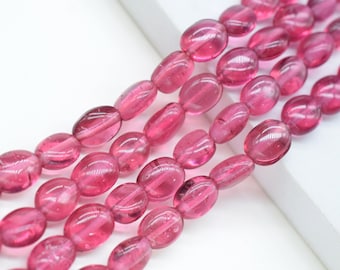 Puede incluir: Una hebra de cuentas de piedras preciosas ovaladas de color rosa. Las cuentas son translúcidas y tienen un ligero brillo.