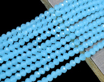 May include: A strand of light blue faceted gemstone beads. The beads are small and round, and they are strung together on a clear thread.