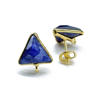 May include: A pair of gold triangle earrings with blue gemstone accents. The earrings have a post back closure.