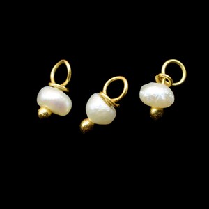 Puede incluir: Tres abalorios dorados con detalles de perlas blancas. Cada abalorio tiene un peque&ntilde;o bucle en la parte superior para sujetarlo a joyas.