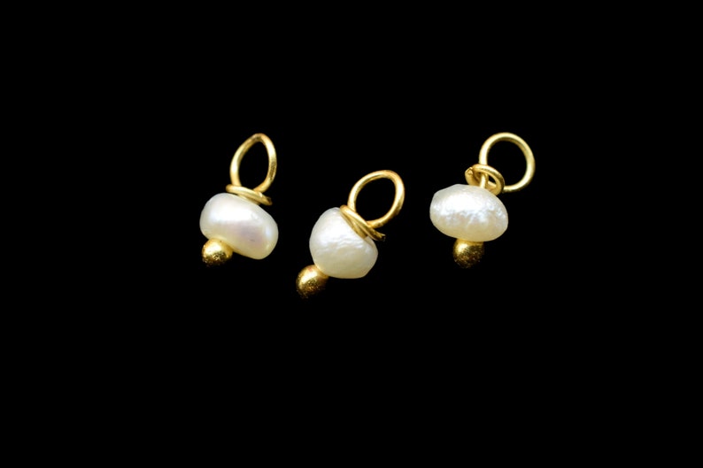 Puede incluir: Tres abalorios dorados con detalles de perlas blancas. Cada abalorio tiene un peque&ntilde;o bucle en la parte superior para sujetarlo a joyas.