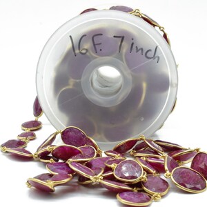 Puede incluir: Un carrete de cuentas de piedras preciosas de color rojo rub&iacute; con detalles dorados. Las cuentas son de forma ovalada y miden 17,78 cm de largo. El carrete est&aacute; etiquetado con "16F. 7 inch".