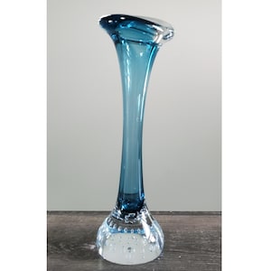 May include: A tall, elegant glass vase with a flared top and a slender, elongated body. The vase transitions from a clear, bubble-filled base to a gradient of deep teal blue. The vase is approximately 12 inches tall, perfect for displaying flowers.