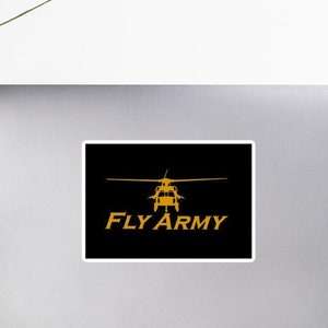 Puede incluir: Una pegatina negra y dorada con la silueta de un helicóptero y el texto "FLY ARMY".