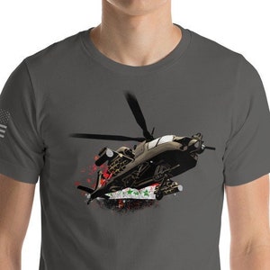 Könnte beinhalten: Ein dunkelgraues T-Shirt mit einem Aufdruck eines Militärhubschraubers, der mit Raketen und Rauch fliegt. Der Hubschrauber ist in Braun- und Grautönen gehalten.