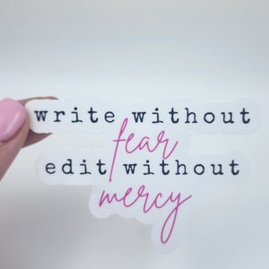 May include: White sticker with black text that reads "write without fear edit without mercy". The word "fear" is in pink cursive.