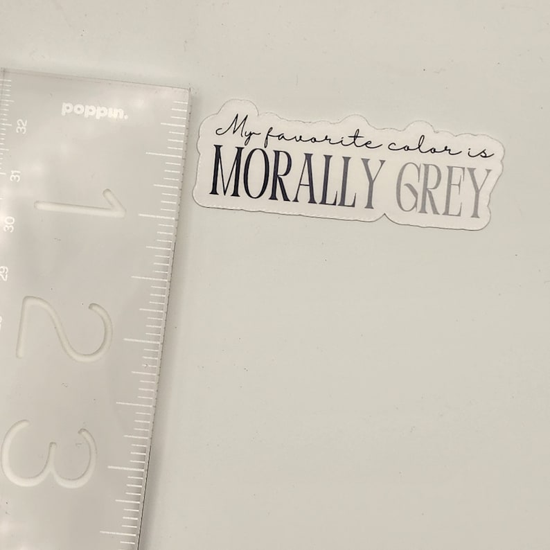 May include: A white sticker with rounded corners and a black outline. The sticker says "My favorite color is MORALLY GREY" in a handwritten font.