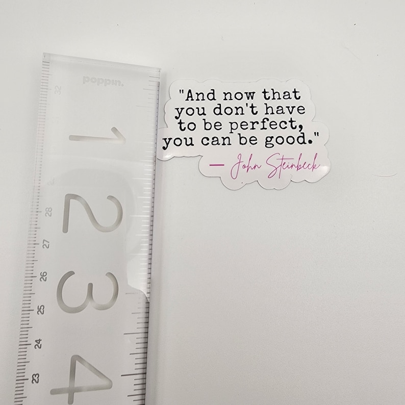 May include: A white sticker with a quote by John Steinbeck: "And now that you don't have to be perfect, you can be good."