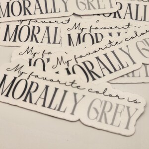 May include: A collection of stickers with the text "My favorite color is morally grey" printed on them. The stickers are white with black text.