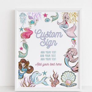 Può includere: Un cartello stampabile a tema sirene. Il cartello presenta sirene, conchiglie, stelle marine e un delfino. Il testo sul cartello recita "Custom Sign", "Add your text" e "Add your text here".