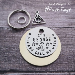 Può includere: Una collezione di targhette per animali domestici e portachiavi in metallo. Un'etichetta è stampata con "I'M GEORGE PLEASE CALL MY WITCH" e una grafica di cappello da strega. Sono inclusi anche un ciondolo dei Doni della Morte e un portachiavi. Le targhette sono argentate e dorate.