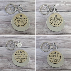 Könnte beinhalten: Vier verschiedene goldene und silberne Schlüsselanhänger mit Anhängern und einem runden Anhänger mit der Aufschrift "Indoor Cat" in verschiedenen Designs. Der erste Schlüsselanhänger hat einen Zauberhut und Sterne, der zweite ein Dreieck mit einem Kreis darin, der dritte ein Herz mit der Aufschrift "Love my Cat" und der vierte einen Halbmond und einen Stern.