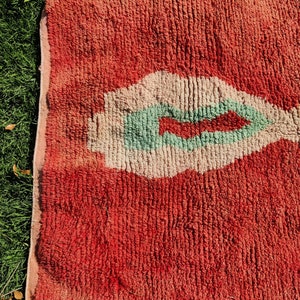 Puede incluir: Una alfombra roja, blanca y verde con un dise&ntilde;o abstracto &uacute;nico. La alfombra tiene una superficie texturizada y esponjosa.