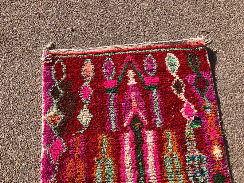 Puede incluir: Una alfombra marroqu&iacute; colorida con fondo rojo y intrincados patrones geom&eacute;tricos en tonos de rosa, verde y naranja.