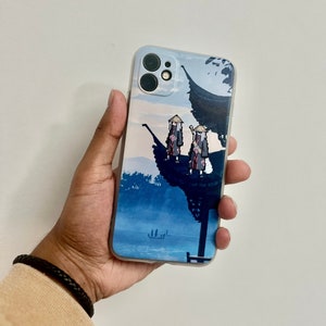 May include: A light blue iPhone case featuring a scenic illustration of a mountain landscape with two figures. The case has a clear border and a detailed design with shades of blue and red.