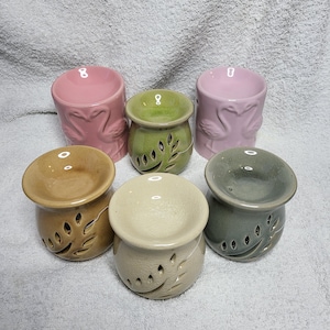 Può includere: Sei diffusori di olio in ceramica di vari colori, tra cui rosa, verde, marrone e grigio. Ogni diffusore presenta un design unico con un motivo a foglie.