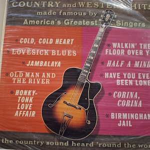 May include: Vintage vinyl record album cover featuring a stylized illustration of a hollow-body guitar. The cover is divided into sections of orange and pink, with song titles and the text "COUNTRY and WESTERN HITS" and "America's Greatest Singers".