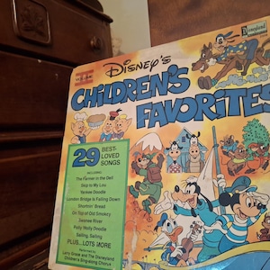 May include: A vintage Disney's Children's Favorites record album cover. The cover features colorful illustrations of Disney characters like Mickey Mouse, Donald Duck, and Goofy. The album includes 29 best-loved songs, with titles listed on the front.