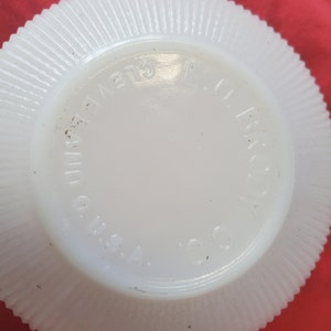 May include: White milk glass plate with a scalloped edge and the words "Fire King USA" printed on the bottom.