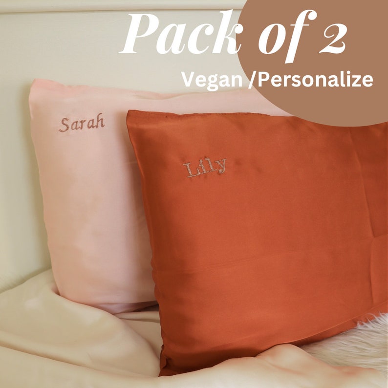 Puede incluir: Dos fundas de almohada personalizadas, una rosa con el nombre "Sarah" bordado y una naranja con el nombre "Lily" bordado. Las fundas de almohada est&aacute;n hechas de seda vegana y son parte de un paquete de dos.
