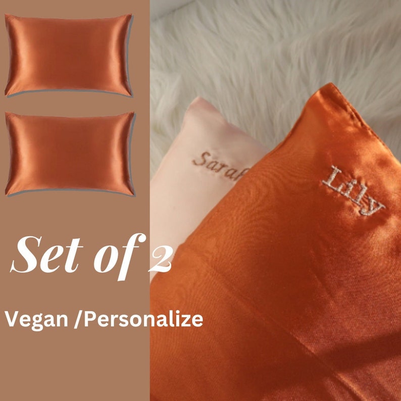 Puede incluir: Conjunto de dos fundas de almohada de sat&eacute;n naranja con los nombres "Lily" y "Sarah" bordados. Las fundas de almohada son veganas y se pueden personalizar.