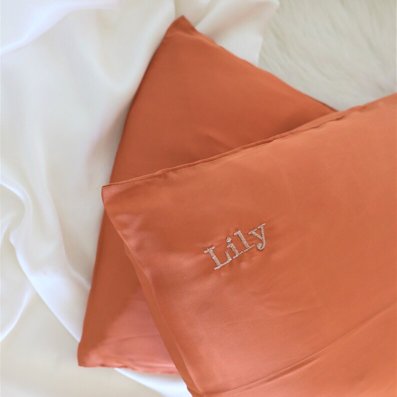Puede incluir: Dos fundas de almohada de color &oacute;xido con el nombre "Lily" bordado en una de las fundas de almohada.