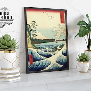 May include: A framed Japanese woodblock print of a wave with Mount Fuji in the background. Three white ceramic planters with gold accents and green succulents are arranged on a white marble shelf.