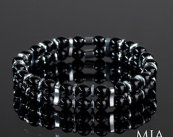May include: A black onyx and hematite beaded bracelet with silver accents. The bracelet is made of two rows of beads and has a simple, elegant design.