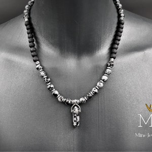 May include: A black and white gemstone necklace with a silver pendant. The necklace is made of round beads and has a silver clasp. The pendant is a small, silver, crystal-shaped charm.