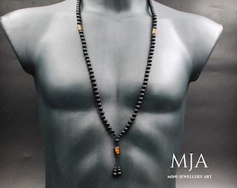 May include: A long black beaded necklace with a rectangular amber-colored accent bead and a tassel. The necklace is displayed on a black mannequin. The necklace is a piece of jewelry.