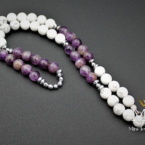 K&ouml;nnte beinhalten: Eine Halskette aus wei&szlig;en Howlith- und Amethyst-Edelsteinen mit silbernen Perlen. Die Halskette hat einen silbernen Verschluss und ist etwa 45 cm lang.