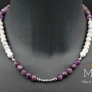 K&ouml;nnte beinhalten: Eine violette Amethyst- und wei&szlig;e Howlith-Perlenkette mit silbernen Akzenten. Die Kette befindet sich an einem Mannequin-Hals. Der Text "MJA Mine Jewellery Art" befindet sich in der unteren rechten Ecke des Bildes.
