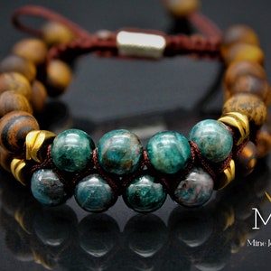 May include: A brown and green beaded bracelet with gold accents. The bracelet is made with tiger's eye and green aventurine beads. The bracelet is tied with a brown cord and has a silver clasp.