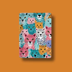 May include: A rectangular notebook featuring a colorful pattern of stylized leopard faces in shades of pink, blue, yellow, and white. The design is repeated across the cover, creating a playful and eye-catching aesthetic. The notebook has a clean, modern design.