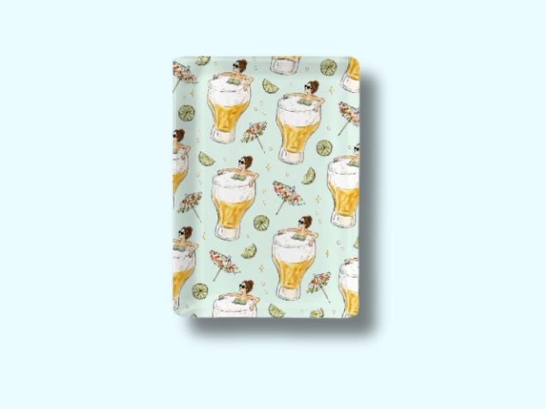 May include: Rectangular serving tray with a repeating pattern of beer glasses, women in sunglasses, lime slices, and cocktail umbrellas on a light green background. The tray has a white border and is likely made of ceramic or a similar material.