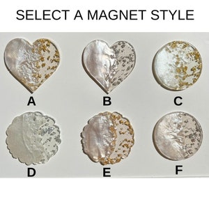 May include: A range of decorative magnets in heart and circular shapes. The magnets have a pearlescent finish with gold and silver leaf detailing. The text "SELECT A MAGNET STYLE" is displayed at the top of the image.