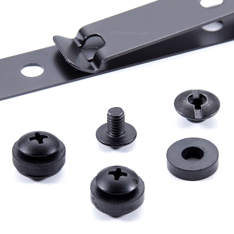 May include: A set of black metal and rubber hardware for mounting a device. The set includes a metal strap with a hole, a screw with a washer, a rubber washer, and a screw with a rubber washer.