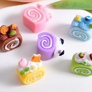 May include: Six miniature cake rolls in various colors and designs. The cakes are decorated with frosting, sprinkles, and other embellishments. The cakes are made of polymer clay and are perfect for dollhouse or miniature food displays.