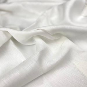 Può includere: Tessuto di lino bianco con una texture liscia e morbida. Il tessuto è piegato e drappeggiato, mostrando le sue rughe e pieghe naturali.