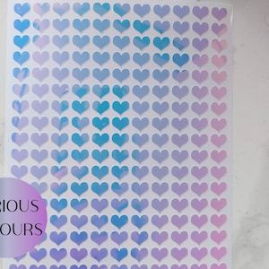 May include: A sheet of heart-shaped stickers in shades of blue, purple, and pink. The stickers are arranged in a grid. A circular graphic in the lower left corner reads "VARIOUS COLOURS".