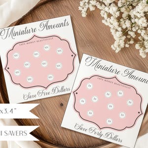 Puede incluir: Dos rastreadores de ahorro cuadrados de papel blanco con marcos festoneados rosas. Una tarjeta dice Miniature Amounts, Save Money Beautifully y Save Five Dollars con círculos de 50c. La otra dice Save Forty Dollars con círculos de $4. Tamaño 8,6x8,6 cm.