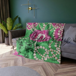Op de afbeelding: Groene deken met een roze roos en parelkettingen. De tekst "Paris" staat in het midden van de roos. De tekst "Pink Boutique" staat rechtsonder.