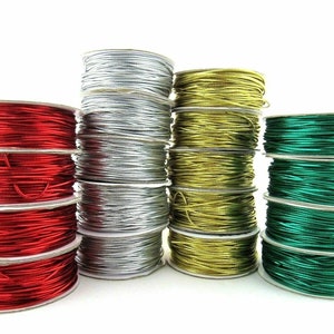 May include: Spools of red, silver, gold, and green elastic cord. The cord is wound around white cardboard spools.