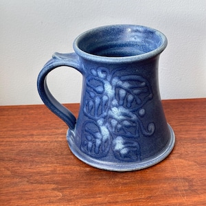 Può includere: Un set di tre tazze in ceramica con finitura opaca e macchiettata. Le tazze sono nei toni del crema, grigio chiaro e grigio scuro. Ogni tazza ha un design semplice e minimalista.