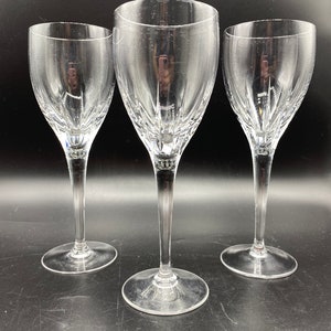 Op de afbeelding: Drie heldere glazen wijnglazen met een geslepen kristallen ontwerp. De glazen hebben een lange, slanke steel en een ronde kom.
