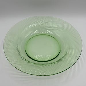 May include: A green glass salad plate with a swirl design.