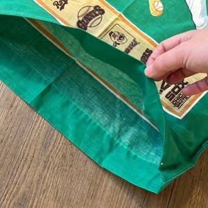 May include: Green fabric with a white and gold border. The fabric has images of baseball teams, including the Giants, Royals, and White Sox.