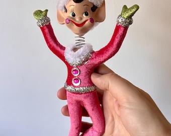 Retro vintage iconische kerstelfen met roze veloursoutfits en bobbelhoofdjes