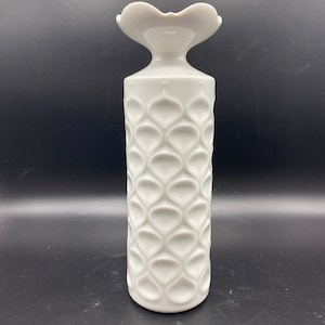 Puede incluir: Jarrón de cerámica blanco con una abertura en forma de corazón y un patrón texturizado de círculos superpuestos.