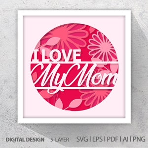 Puede incluir: Un diseño de corte de papel en capas de color rosa y blanco con el texto "I Love My Mom" en un círculo. El diseño presenta flores y hojas.